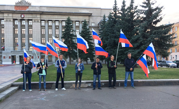 Несогласованное шествие с триколором сопровождали полицейские и неизвестные люди с видеокамерами